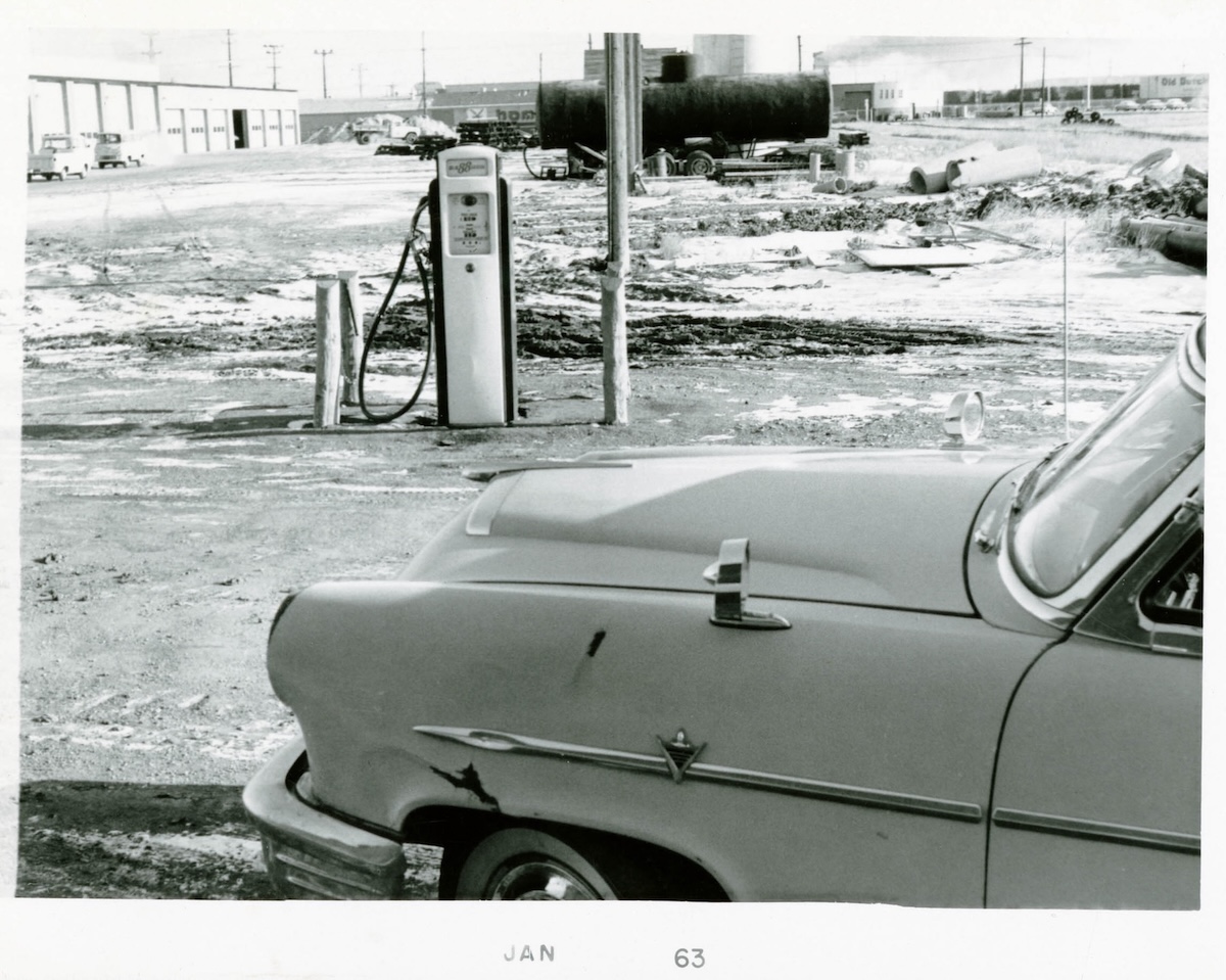 1963 - A car beside a gas pump in St. James railyard